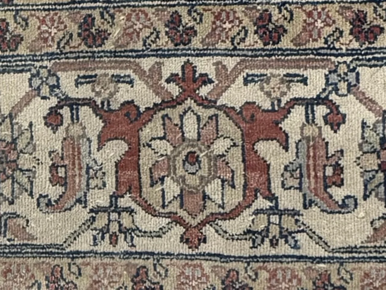 Close-up inspection of fraying and muted color on the Persian 9x12 rug