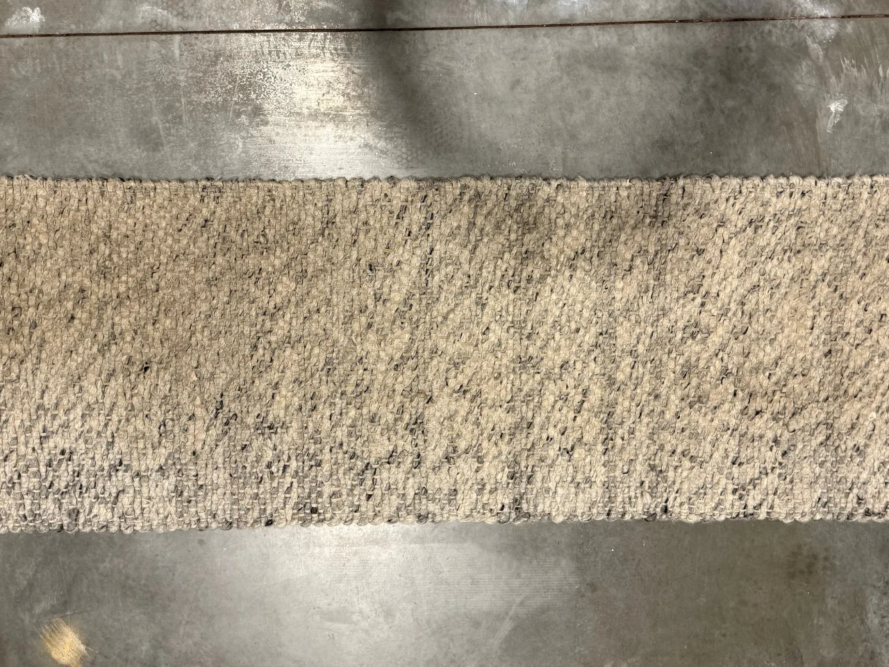 Before: heavily soiled grey wool runner from a Vancouver, WA entryway with dark traffic paths and discolored edges