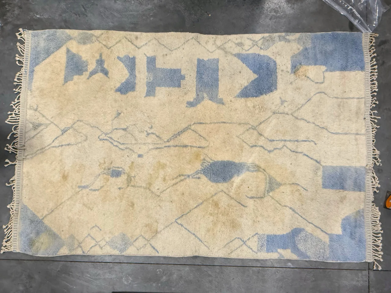 The natural wool 5x7 rug on arrival at the Benchmark plant