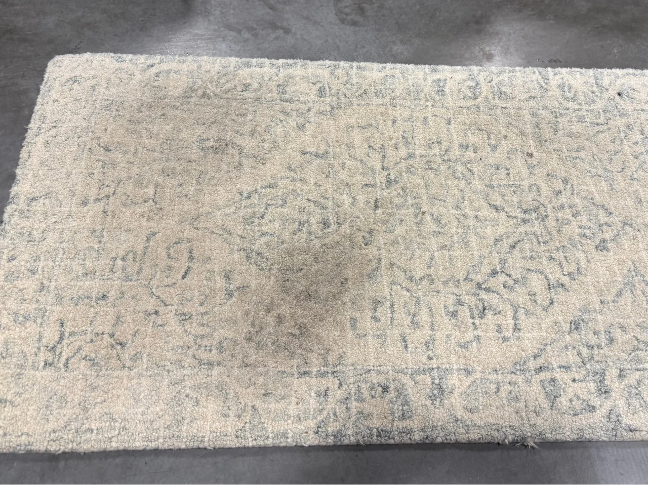 Before: dull, grayish white wool rug with stains and heavy traffic soiling from a Washougal, WA home