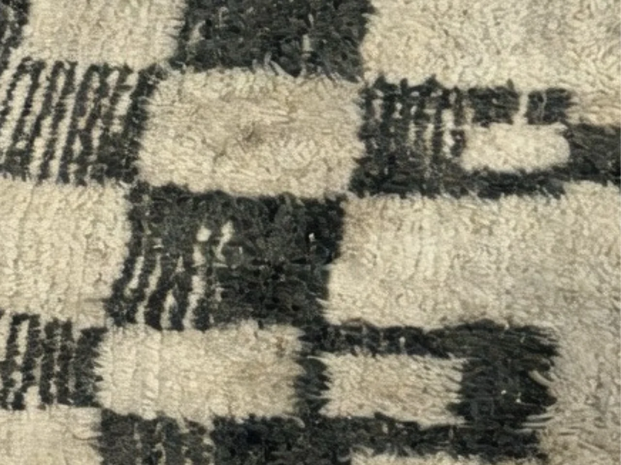 Close-up of the pile and checkerboard pattern of the sheep’s wool rug