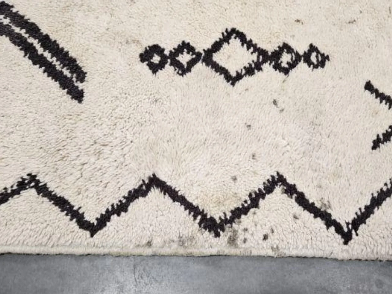 A second close-up of stains on the vintage wool rug before cleaning