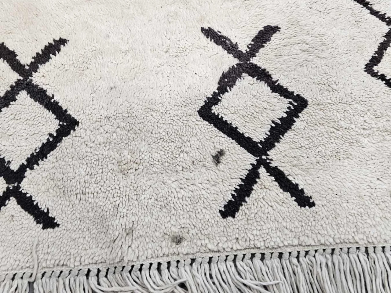 Close-up of set-in stains on the vintage wool rug before cleaning