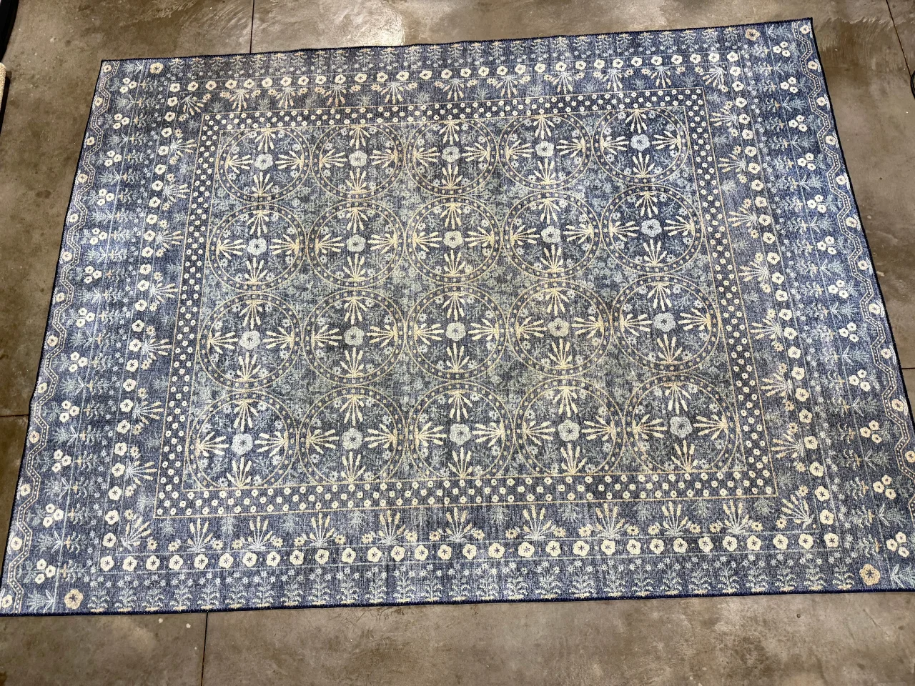 The blue and ivory wool-blend rug on arrival at the Benchmark plant