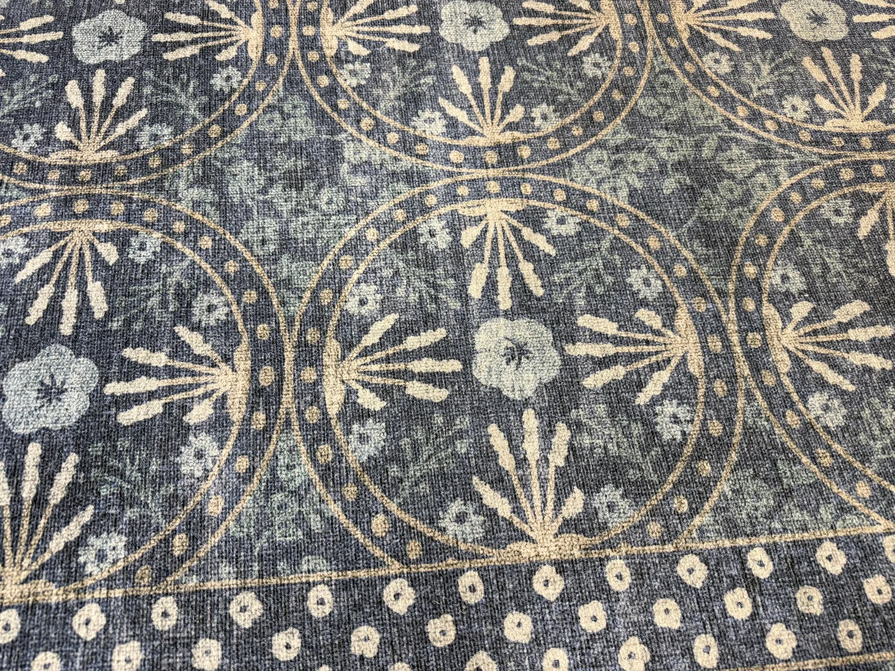 Inspection photo showing stains in the blue and ivory wool-blend rug